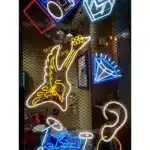 Letreiro neon com guitarra e ícones diversos.