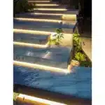 Escadaria iluminada com plantas ao redor.
