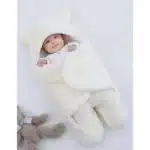 Bebê envolto em cobertor fofinho com capuz de ursos.