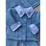 Conjunto de roupa azul para bebê com detalhes em bordado.