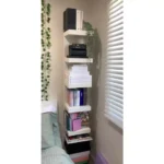 Estante branca com livros e plantas decorativas.