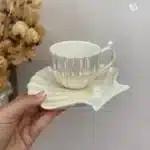 Xícara elegantemente apresentada em pires decorativo.