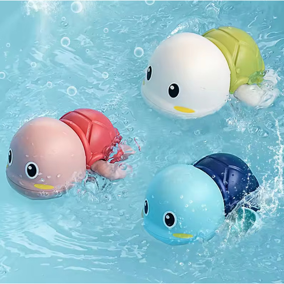 Brinquedo de banho tartaruguinha flutuando na água da banheira com bebê sorrindo